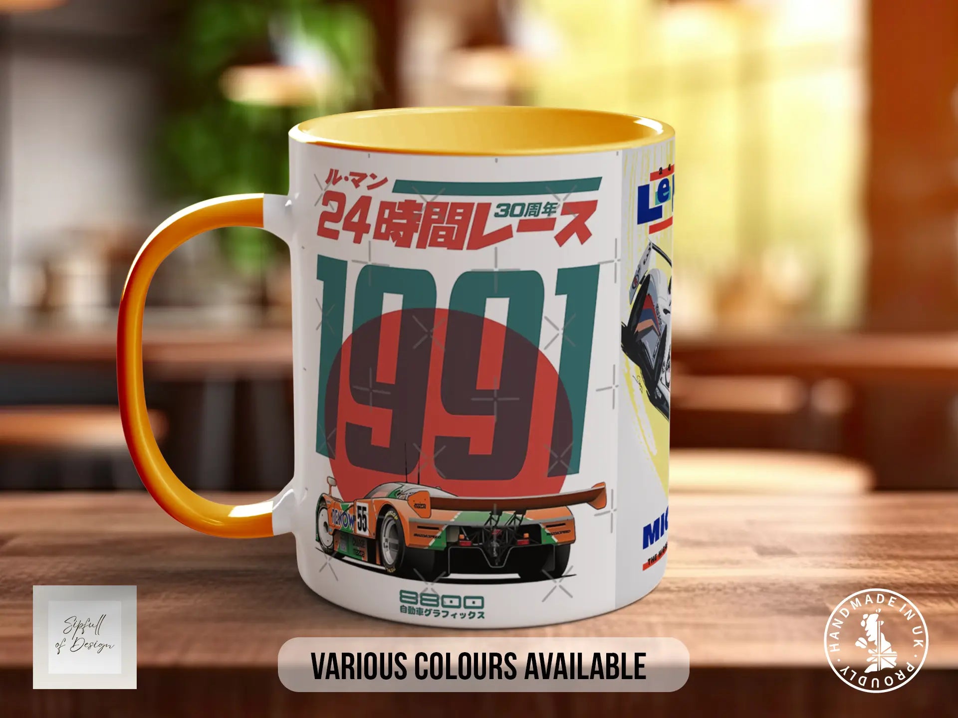 A white and orange mug with a racing car design and Japanese text, along with a blurred background.