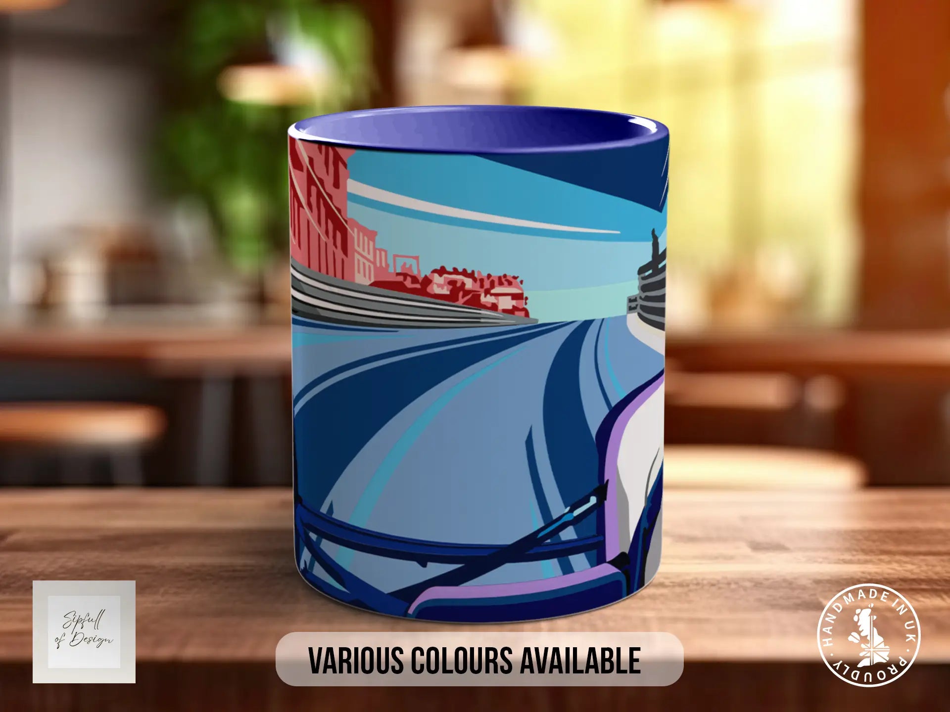 A colorful mug with a graphic design depicting a cityscape with a train on the tracks.