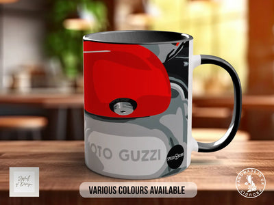 A black and red mug with a graphic design featuring a red car and the text "TOTO GUZZI" on it, placed on a wooden surface.