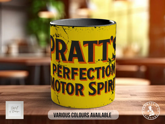 A yellow mug with the text "PATT'S PERFECTION MOTOR SPIRIT" printed on it, sitting on a wooden surface.
