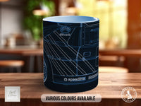 A black mug with a graphic design of a car on it, sitting on a wooden surface.