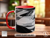 A red and white mug with a camouflage pattern on it, sitting on a wooden surface.