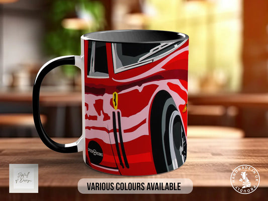 A red and black mug with a graphic design of a car on it, sitting on a wooden surface.