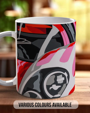 A colorful mug with a graphic design featuring a car or vehicle on the front.