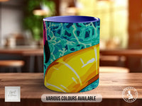 A colorful mug with a vibrant design, placed on a wooden surface.