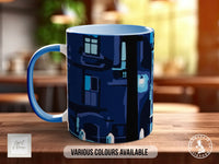 A blue and white mug with a black and blue abstract design on it, sitting on a wooden surface.