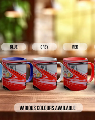 a row of five colorful mugs, each with a different color: light blue, blue, grey, red, and orange. The mugs are arranged on a wooden surface, and there is text indicating that various colors are available.