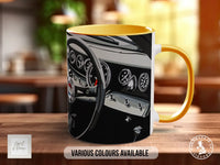 A mug with a graphic of a car's dashboard and steering wheel, along with the text "Various Colours Available" and "Handmade in UK".