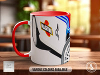 A red and white mug with a graphic design featuring a car and the word "MARTHA" on it, placed on a wooden surface.