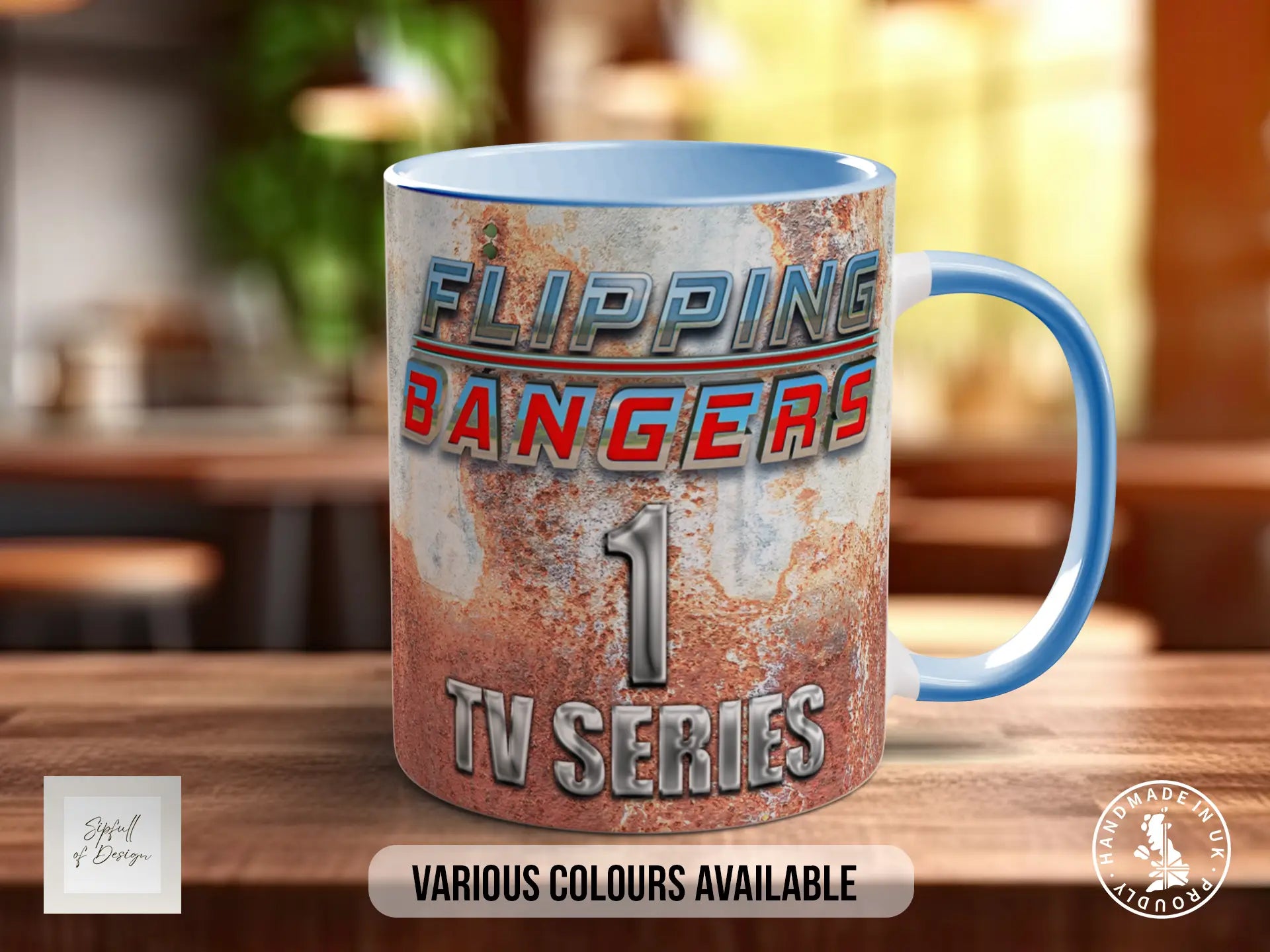A mug with the text "FLIPPING BANGERS" and "1 TV SERIES" printed on it, along with the number "1" and the word "TV SERIES". The mug is placed on a wooden surface, and there is a blurred background that appears to be a kitchen or dining area.