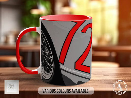 A red and gray mug with a graphic design featuring a wheel and the number 72 on it, placed on a wooden surface.