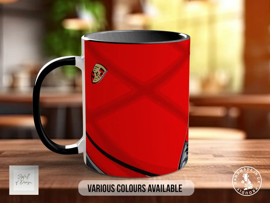 A red and black coffee mug with a black handle, placed on a wooden surface.