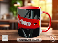 A red and white mug with the word "Marlboro" printed on it, sitting on a wooden surface.