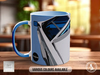 A blue and white mug with a graphic design of a car on it, placed on a wooden surface.