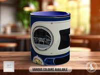 A blue and white mug with a graphic design on it, sitting on a wooden surface.
