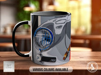 A black and white mug with a graphic design depicting a car's headlight and hood.