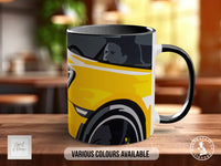 A black and yellow mug with a graphic design of a car on it, placed on a wooden surface.