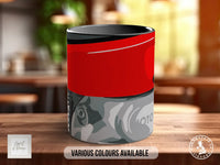 A red and gray mug with a camouflage pattern, placed on a wooden surface.