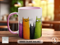 A mug with a colorful cat design on it, featuring cats in various colors such as orange, green, and purple.