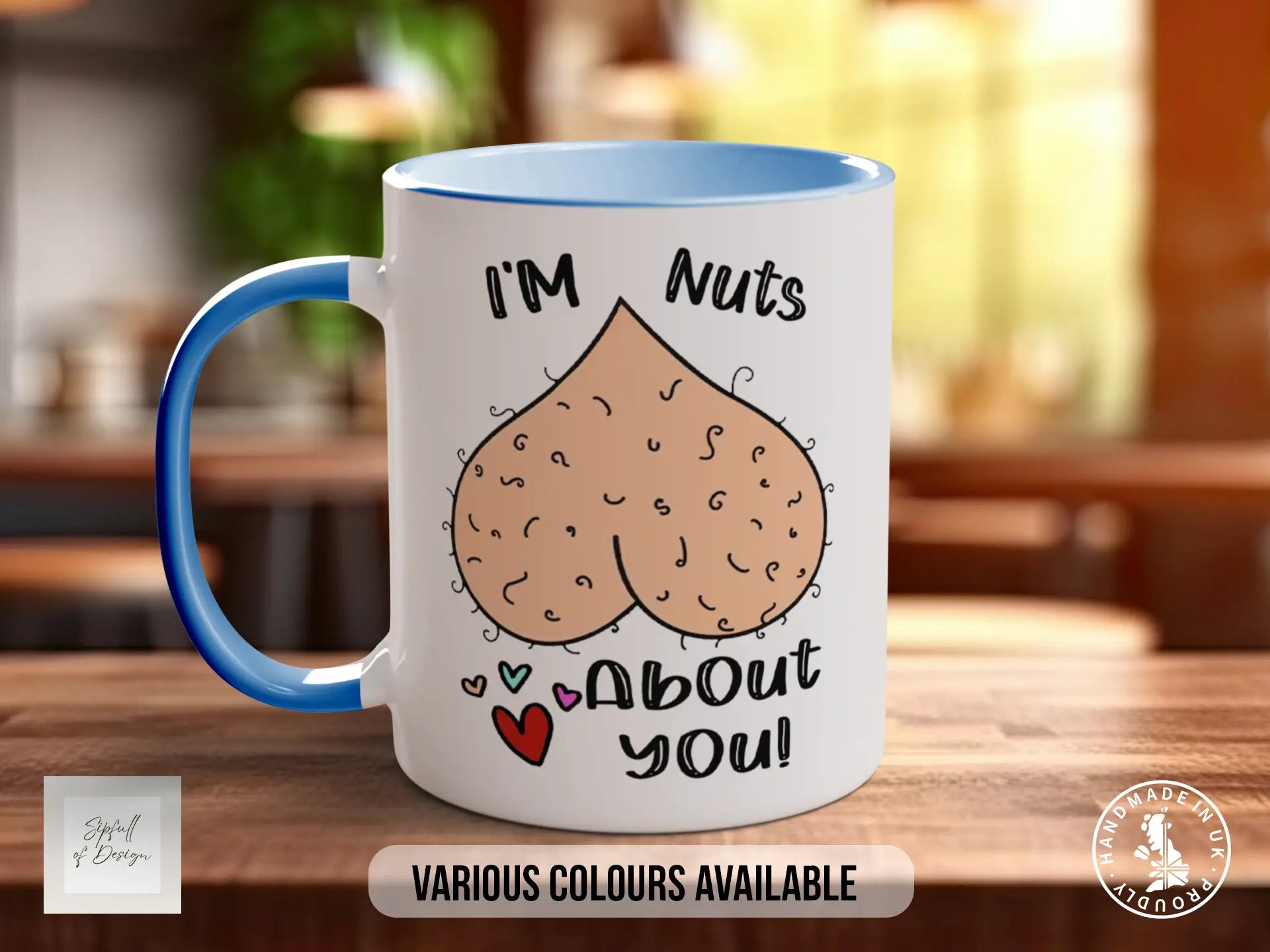 A white mug with a blue handle, featuring a cartoon image of a hairy nut and the text "I'm Nuts About You!" along with the text "VARIOUS COLOURS AVAILABLE" at the bottom.