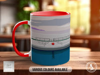 A red and blue mug with a graphic design depicting a swimming pool and a red buoy, placed on a wooden surface.