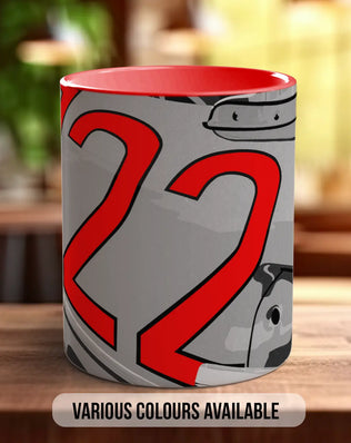 A mug with a red and gray design featuring the number 22, placed on a wooden surface.