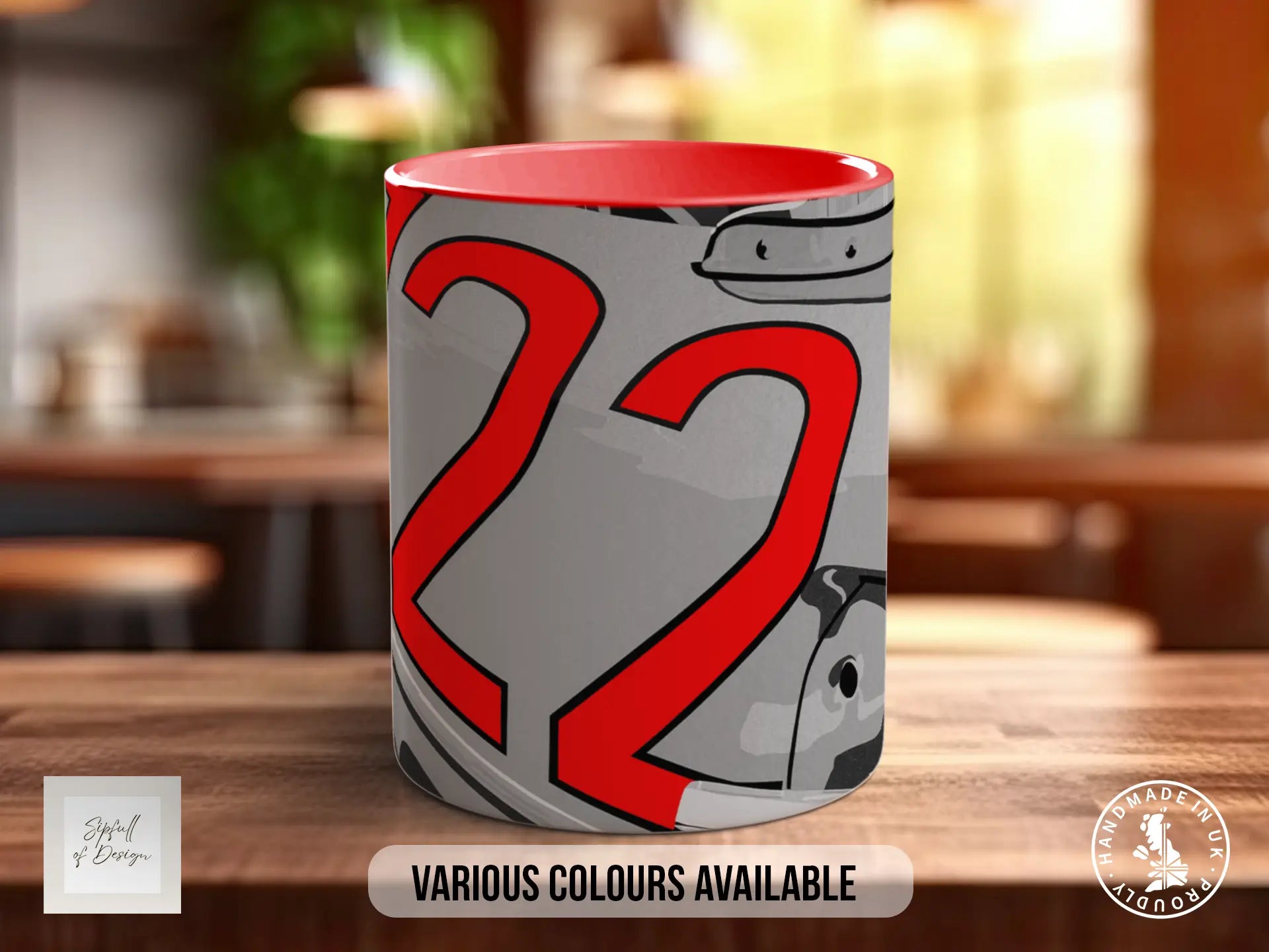 A mug with a red and gray design featuring the number 22, placed on a wooden surface.