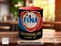 A mug with a faded and worn-out "FINA" logo, indicating it is a motor oil product. The mug is placed on a wooden surface, and there is text indicating that various colors are available.