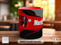 A red and black mug with a graphic design featuring a racing helmet and the text "Marlboro" on it, placed on a wooden surface.