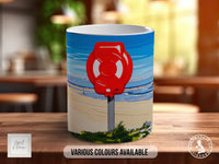 A mug with a beach scene and a red life preserver on it, along with the text "Various colors available" and "Made in UK".