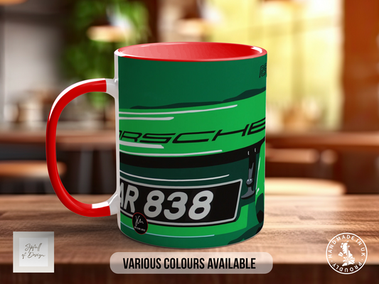 A red and green mug with the text "Porsche" printed on it, sitting on a wooden surface.