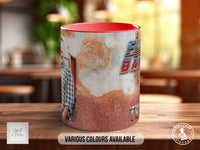 A red and white mug with a rust-colored design featuring a person's face and the text "FLY BABY" on it, placed on a wooden surface.