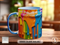 A colorful mug with a dripping paint design, sitting on a wooden surface.