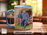 A blue and white mug with a printed photo of two people sitting on a car in the background.