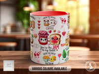 A white mug with a variety of colorful illustrations and text on it, placed on a wooden surface.