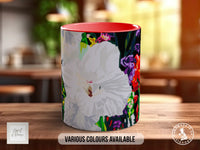 A colorful ceramic mug with a floral pattern on it, placed on a wooden surface.