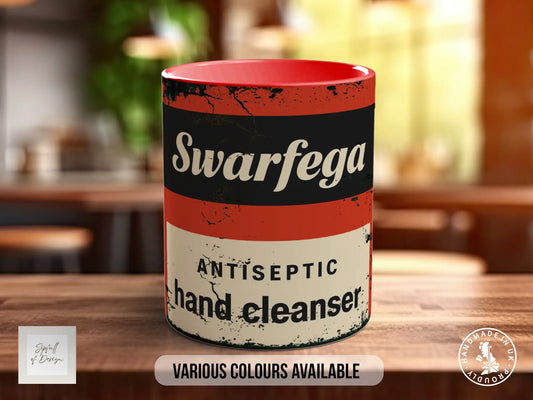 A red and white mug with the text "Swarfega Antiseptic hand cleaner" printed on it, sitting on a wooden surface.