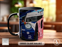 A black and white mug with a colorful design featuring a racing car on a wooden table.