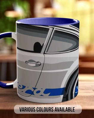 A mug with a graphic of a car on it, sitting on a wooden surface.