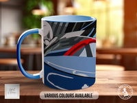 A blue and white mug with a graphic design featuring a car or vehicle on the front.