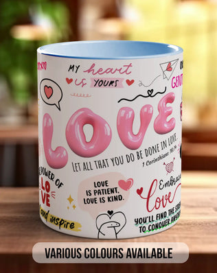 A white mug with the word "LOVE" written on it, surrounded by various phrases and illustrations in pink and red colors.