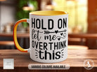 a orange and white coffee mug sitting on top of a wooden table